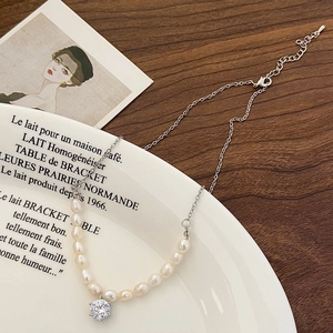 Close-up of vintage baroque pearl pendant with zircon on a decorative ceramic plate