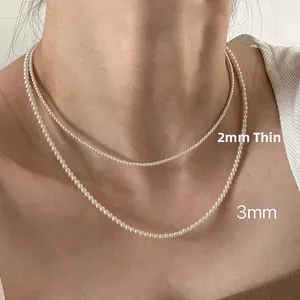 Close-up of double-layered necklace featuring 2mm and 3mm round white pearls