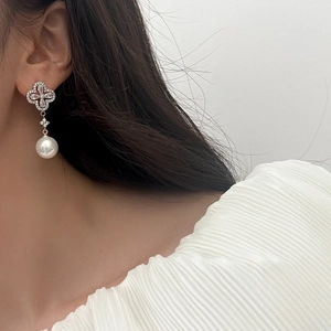 Detail of four-leaf clover stud earring with pavé zircon and hanging white pearl