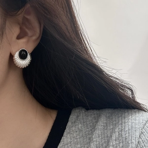 Detail of vintage geometric cat eye stud earring with textured silver and black stone