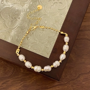 Detail of natural freshwater pearl bracelet with gold beads on vintage wooden frame