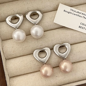 Gros plan détaillé de boucles d'oreilles en argent en forme de cœur et perles