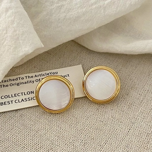 Detail of French vintage gold round stud earrings with white mother of pearl inlay