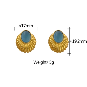 Détail macro de boucles d'oreilles vintage en or avec opale bleue et texture radiale