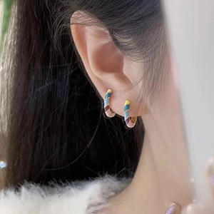 Colorful enamel striped C-hoop earrings with gold plating worn by a model in a close-up view