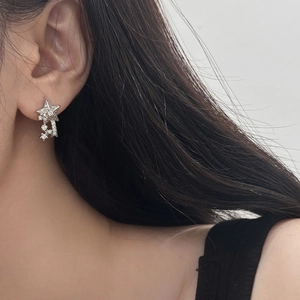 Close-up of sparkling star-shaped stud earrings with inlaid cubic zirconia on a model