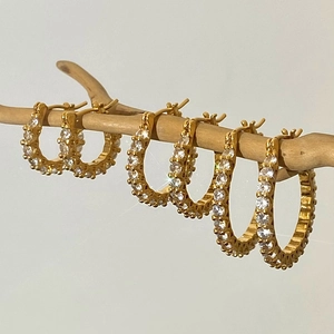 Boucles d'oreilles créoles dorées avec cristaux étincelants sur branche en bois