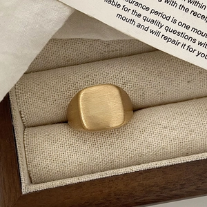Détail macro d'une bague en métal brossé doré avec forme de coussin sur un coffret