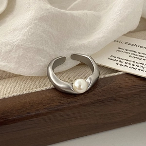 Dettaglio anello aperto irregolare placcato argento con perla bianca su legno