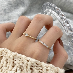 Anello a cuore dorato e fascia di diamanti pavé su mano con maglione lavorato