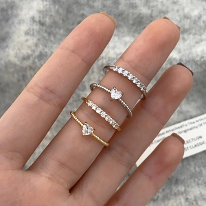 Dettaglio di un set di quattro anelli con zirconi a forma di cuore sulla mano