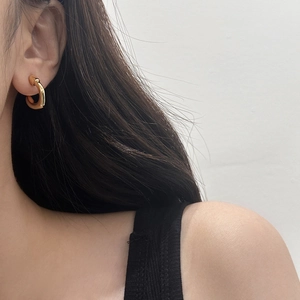 Gros plan d'une boucle d'oreille créole épaisse dorée portée par un mannequin chic