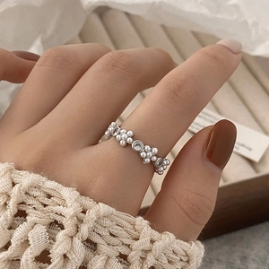 Elegante zilveren parel- en zirkoonbloemring gedragen voor een stijlvolle look