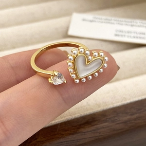 Macro-detail van verstelbare gouden ring met hartvormige steen en micro-parelrand