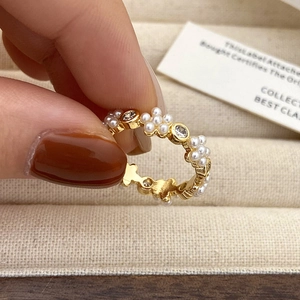 Macro-opname van een gouden bloemring met witte parels en fonkelende zirkonia's