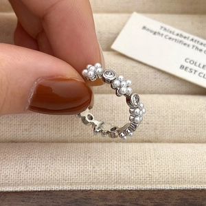 Detail van zilveren ring met afwisselende parels en zirkonia in elegant bloemdesign