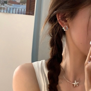 Modella asiatica con collana a stella marina e orecchini a cerchio con perle argentati