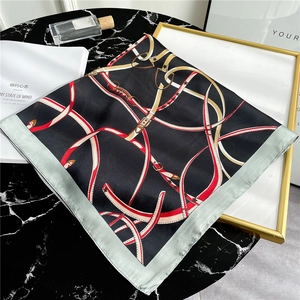 Flat lay of silk square scarf with belt and buckle prints on marble background
