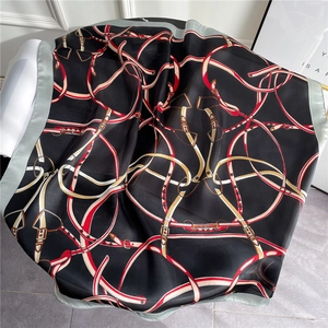 Detail of silk scarf with equestrian belt print and smooth satin texture on marble