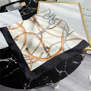 Detail of luxury silk scarf with horse harness pattern on black marble surface