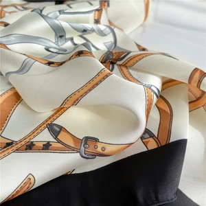 Detailed shot of silk satin scarf with equestrian belt buckle print and star pattern
