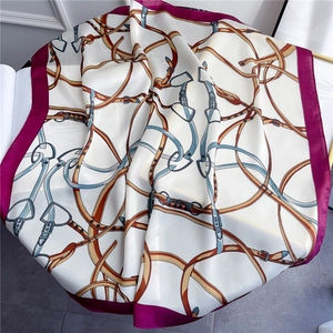 Detail of equestrian square silk scarf featuring belt chain patterns and purple border