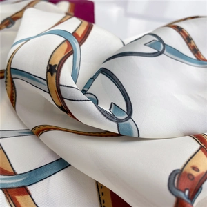 Detailed view of satin scarf showing vintage belt prints and smooth silk texture