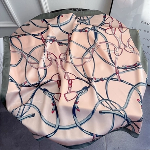 Detail of silk-like square scarf featuring retro belt prints and horse harness patterns