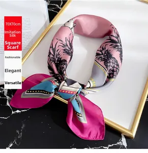 Detail of silk-like satin square scarf with pineapple prints and pink color blocking