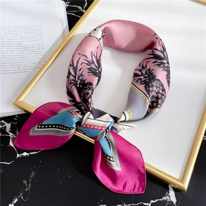 Detail of silk scarf with pink palm tree patterns and geometric polka dot accents