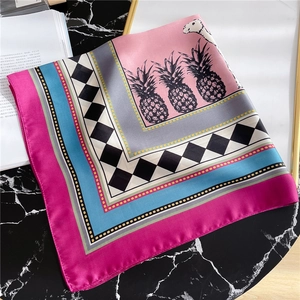 Detailed view of colorful silk scarf featuring pineapple patterns and geometric lattice