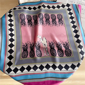 Detail of silk square scarf featuring artistic pineapple pattern and geometric borders