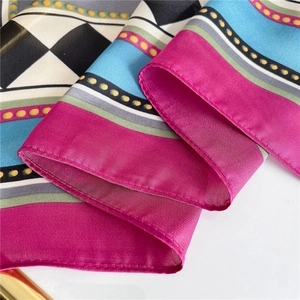 Macro shot of silk scarf fabric showing colorful geometric patterns and fine stitching