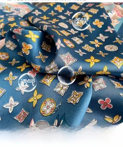 Close-up of soft navy blue silk scarf featuring elegant floral patterns and smooth texture