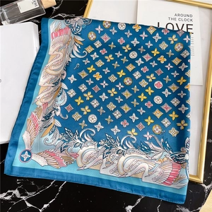 Detail of 70cm silk scarf with vintage swan and logo print on elegant marble setup