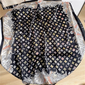 Detailed view of luxury satin scarf with feather prints and monogram patterns on silk fabric