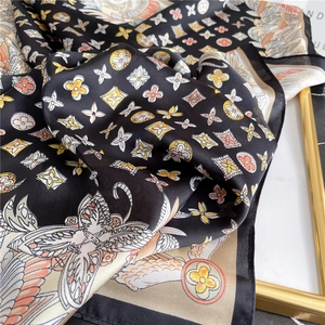 Detailed view of luxury baroque silk scarf with floral monogram pattern and satin finish