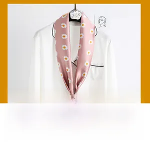 Close-up of a pink floral silk scarf with white daisy patterns tied on a shirt collar