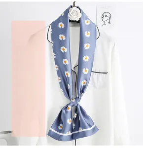 Detailed close-up of blue daisy pattern twilly silk scarf tied on a white shirt collar