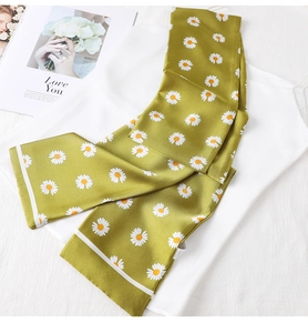 Detail of green silk-like scarf featuring small daisy prints and striped edges