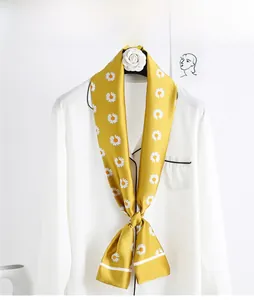 Detail of yellow daisy floral silk scarf styled on a white formal shirt collar