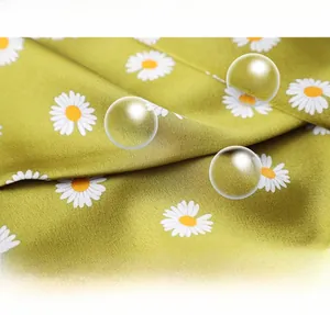 Detail of breathable faux silk scarf featuring white daisy patterns on a green background