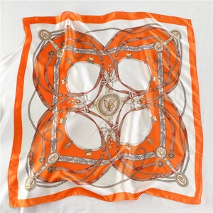Detail of vintage chain and floral print pattern on a high-gloss satin silk square scarf