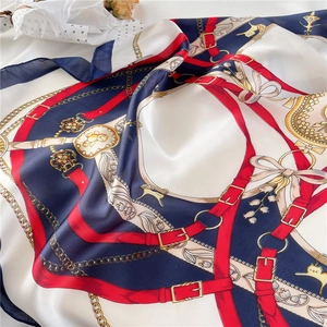 Close-up of silk satin scarf featuring equestrian strap patterns and floral prints