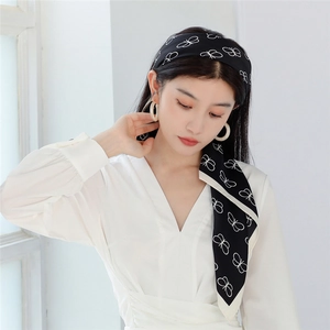 Detail of black and white butterfly print silk scarf worn as a stylish headband