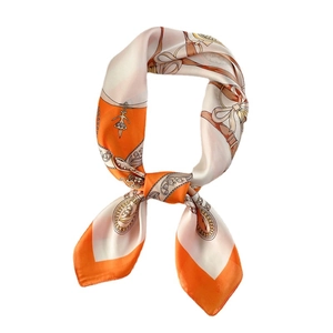 Orange and ivory silk-like scarf with chain patterns and bow ties on white background