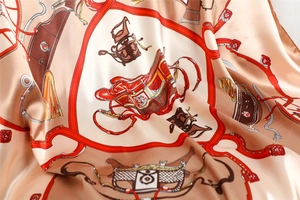 Detail of silk square scarf featuring classic horse carriage print and satin texture