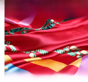 Gros plan d'un foulard en soie carré avec base rouge et motifs de chaîne colorés