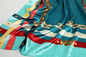 Détail d'un foulard en soie avec imprimé chaîne vintage, léopard et blocs de couleurs
