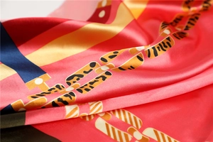 Gros plan d'un foulard en soie avec des motifs de chaînes dorées et des détails léopard